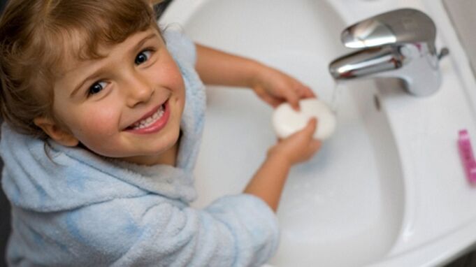 il bambino si lava le mani con il sapone per prevenire i vermi